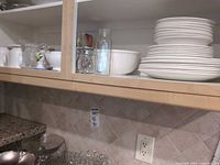 Cabinet shelf with Wedgwood Nantucket plates, bowls, cups and glass jars