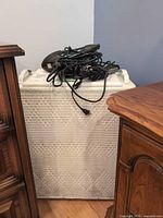 Hamper with hair dryer and cords on lid