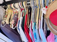 Closet rod with multiple tops, sweaters, straw hat and visor