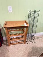 wooden wine rack beside metal CD/DVD tower