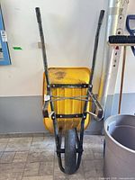 Front view of wheelbarrow upright against wall