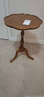 Full view of side table showing scalloped top and tripod pedestal base