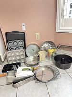 Group shot of assorted bakeware, rolling pin, mixer, racks and measuring items