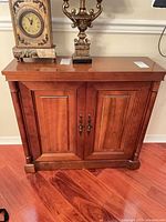 Front view showing paneled doors, hardware, columns and base.