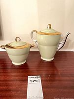 Teapot and sugar bowl side by side on table