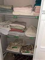 Folded bedding and blankets on wire shelves