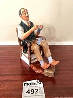 Front view of Royal Doulton figurine seated on chair