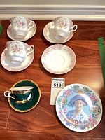 Group shot showing all teacups, saucers, demitasse and commemorative plate