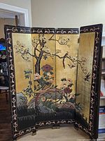 Front of screen showing gold leaf panels with chinoiserie birds and flowers
