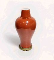 Front view of coral red meiping vase on brass mount