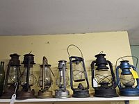 Row of vintage kerosene lanterns on shelf
