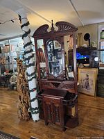 Full view of mahogany hall tree showing crest, mirror, drawers, side stands and cabinet