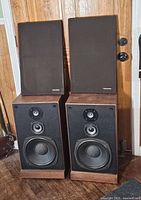 Front view of both Realistic Optimus-25 speakers with grilles removed showing drivers