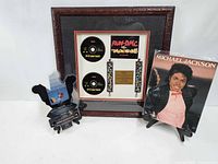 Group view of framed plaque, shaped vinyl and book