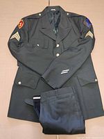 Full uniform laid flat – coat with patches, trousers folded