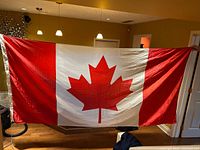 Full view of Canadian flag held open to show design and condition