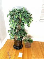 Tall ceramic planter with faux tree and smaller metal planter beside it