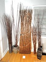All five twig bundle arrangements against wall showing height and bases