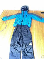 Full view of jacket and snow pants laid out