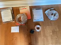 All five light sets arranged on floor: two Hampton Bay kits, Flexilight 12 ft, unknown clear rope light, solar string