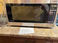 Front view showing stainless-look finish, control panel, display powered on