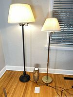 Black and brass-tone floor lamps with small side lamp on floor