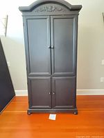 Front view of closed matte black entertainment cabinet