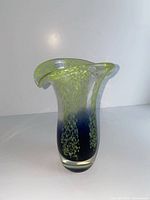 Front view of vase showing lime green mottling, purple-blue lower section, clear base, flared rim