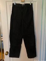 Full front view of black Uniqlo jeans hanging