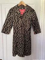 Front view of giraffe print coat on hanger