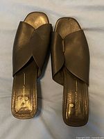 Top view of mules showing black leather uppers and square toes