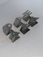 Six geometric stainless steel napkin rings arranged on surface