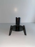 Front view of candle holder showing legs, round base, candle socket