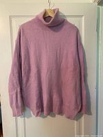 Full front view of lilac ribbed turtleneck sweater hanging