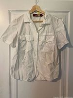 Full view of white short-sleeve button-up shirt on hanger