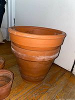 Side view of stacked large terracotta pots highlighting size and mineral residue