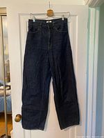 Full view of jeans front showing dark indigo color, wide leg