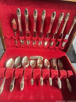 Open flatware case showing arrangement of flatware pieces in red velvet interior