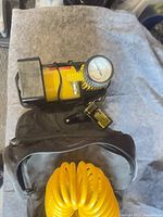 Yellow cylinder-style air compressor with pressure gauge, hose and case
