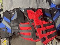 Black and blue XPS vests and red Mustang or Buoy-O-Boy vest