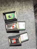 Three boxed Zippo lighters showing front graphics and boxes