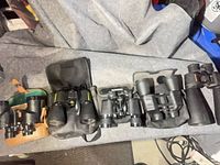 All six binoculars lined up showing cases and straps