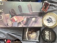 Lot overview with golf print, wolf print, Maple Leafs clock, AC/DC clock, red car plaque