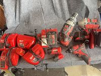 Group shot of drills, chargers and batteries laid on grey surface