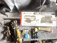 All items laid out: boxed helicopter, bracer, figures, truck, string spool