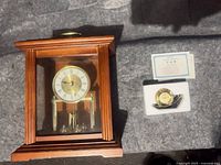 Seth Thomas mantel clock next to boxed Seiko desk clock and paperwork