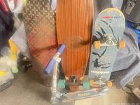 All four items grouped: Evolution skateboard, wood longboard, patterned deck, Razor scooter