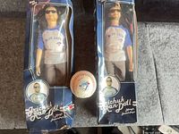 Two boxed Grichuk Ran-Doll figures beside team-signed Blue Jays baseball