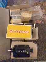 Open box showing multiple smaller boxed counters and one unboxed unit with 00000 display