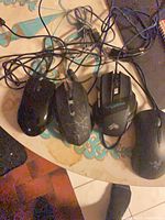 Four wired mice laid out showing top views and attached cables